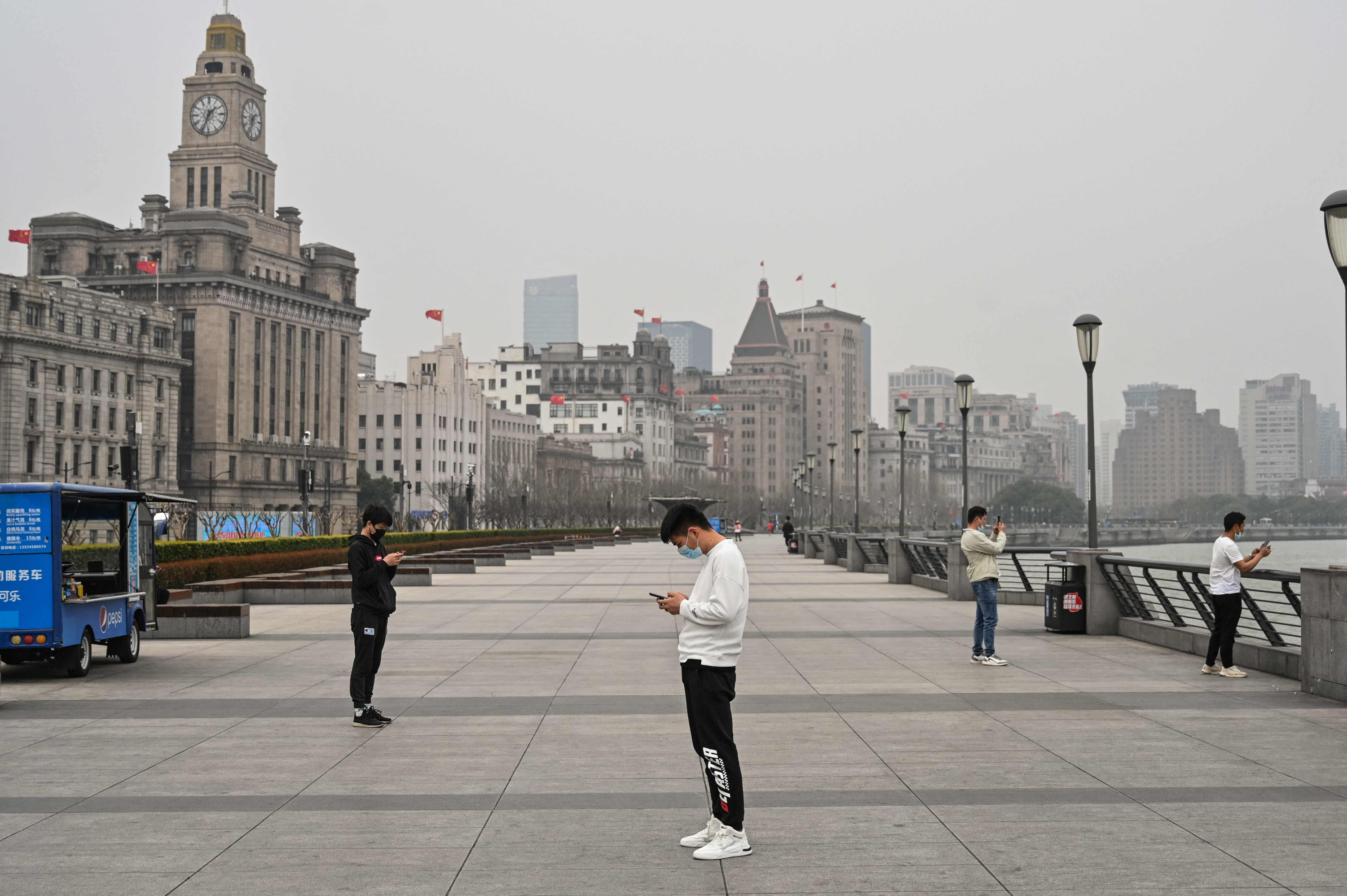 La gente se ve en el paseo marítimo del Bund a lo largo del río Huangpu en Shanghái. Foto: AFP