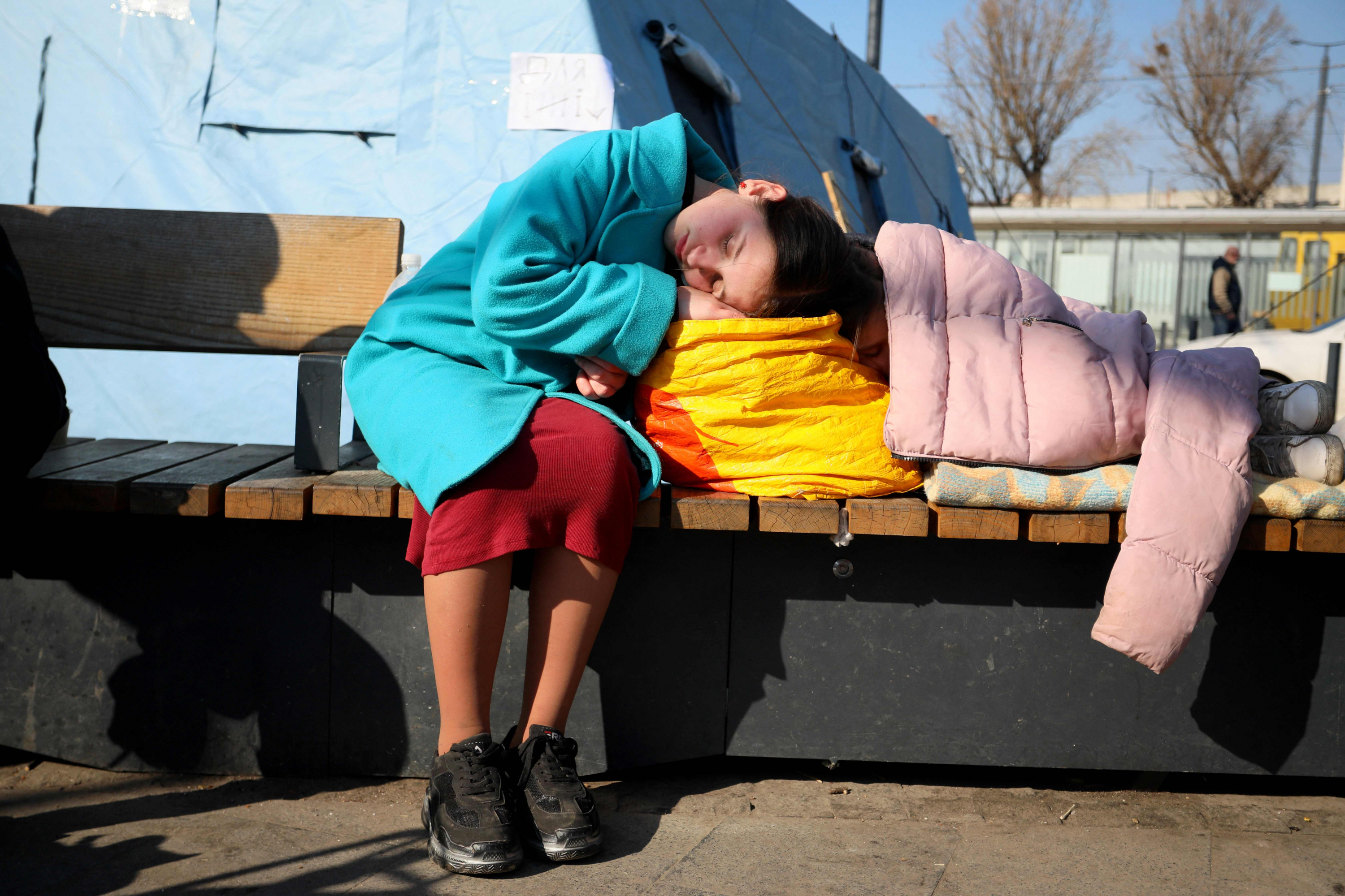 Una niña duerme fuera de la estación de tren de la ciudad ucraniana de Lviv. Foto: AFP.