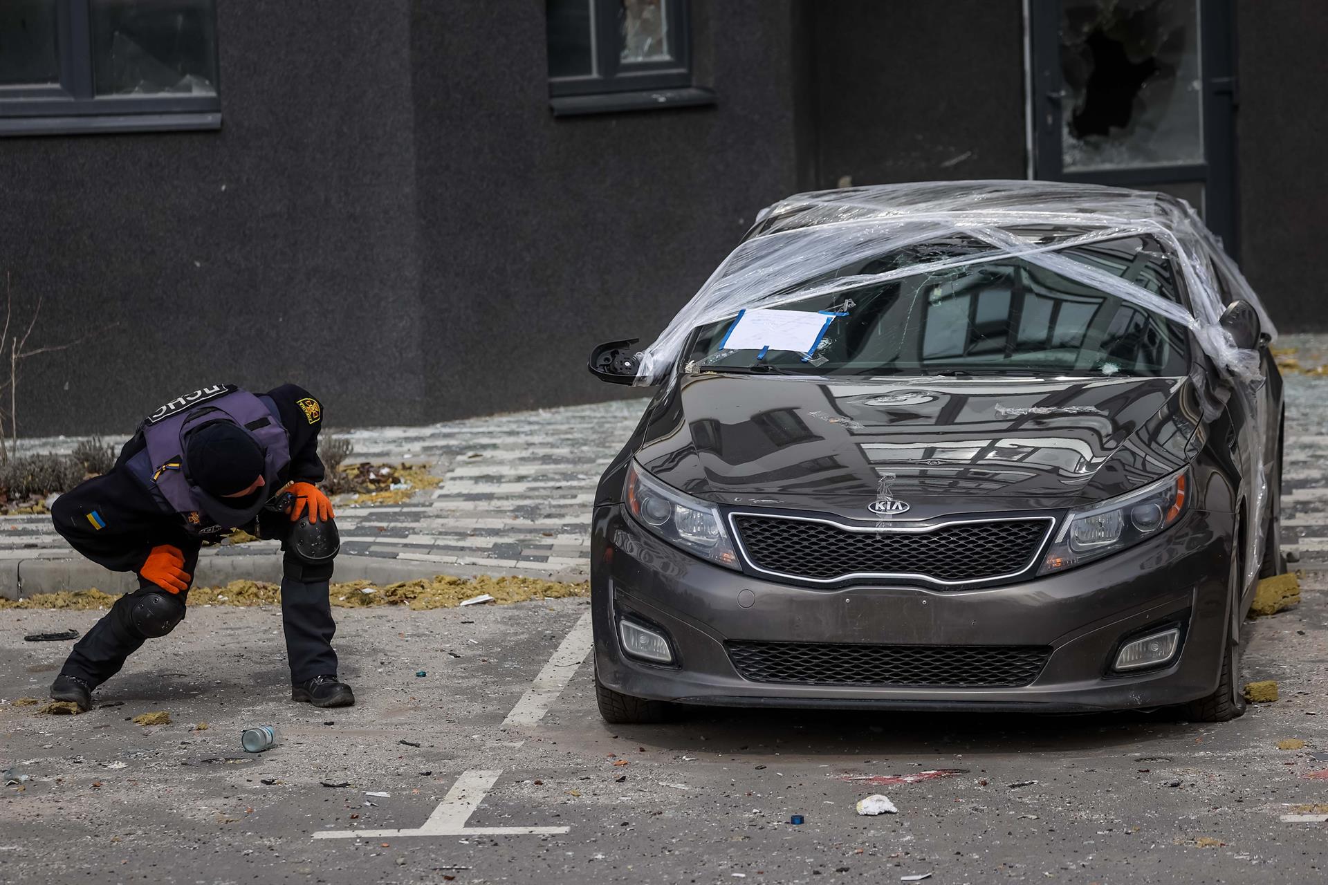Soldados ucranianos buscan minas debajo de un auto en Bucha Foto: EFE