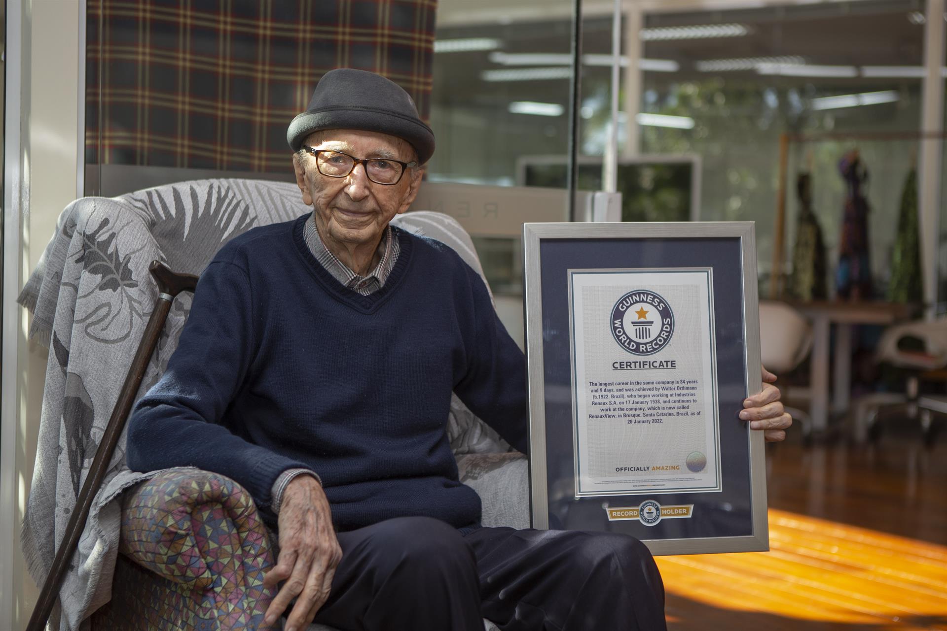 Walter Orthmann, de 100 años, posa junto a su certificado de récord Guinness por la carrera profesional más larga en la misma empresa, el 12 de mayo de 2022 en Brusque, estado de Santa Catarina. Foto: EFE