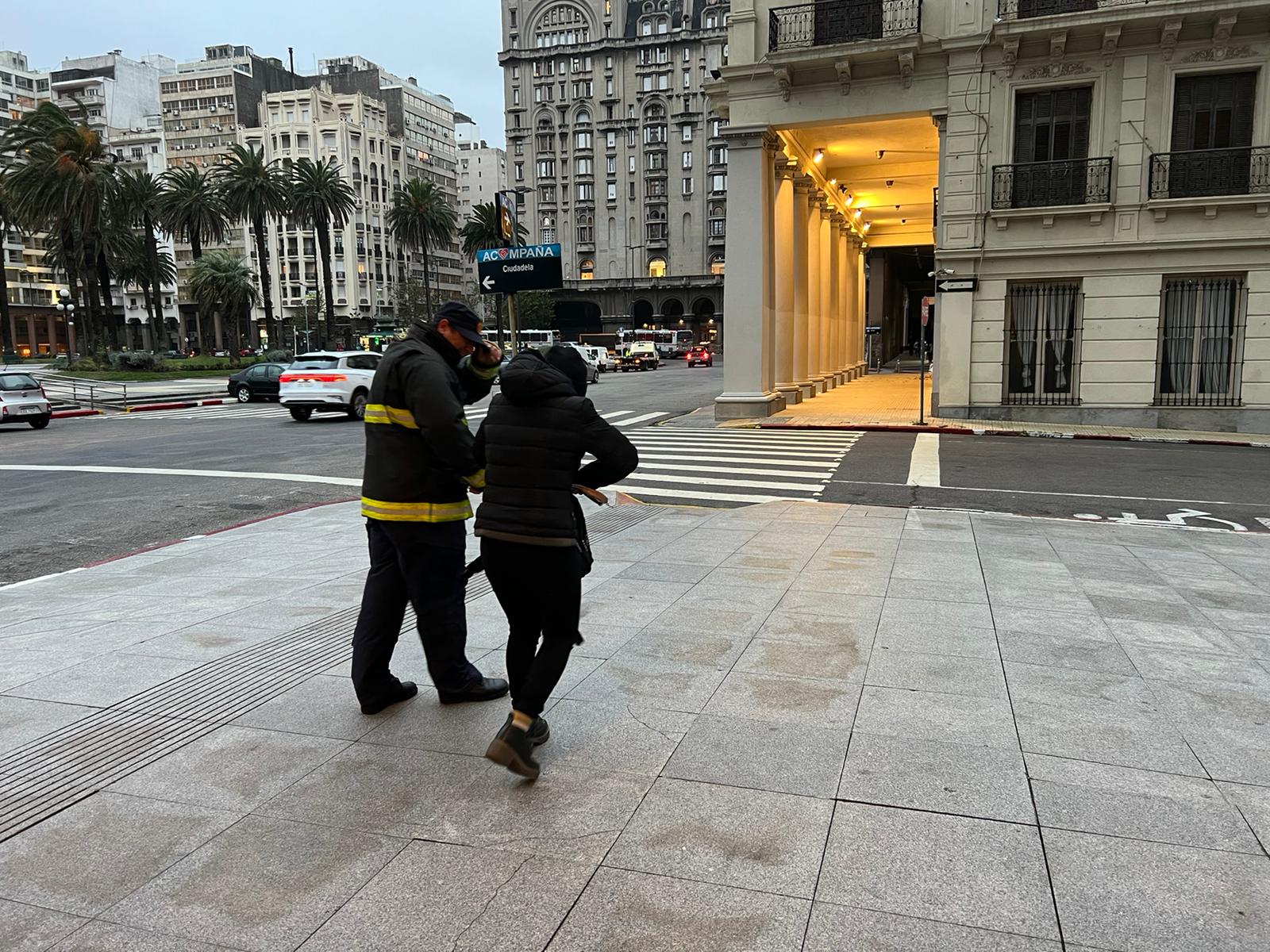 Bombero ayuda a peatón por los fuertes vientos en Montevideo. Foto: Pablo S. Fernández.