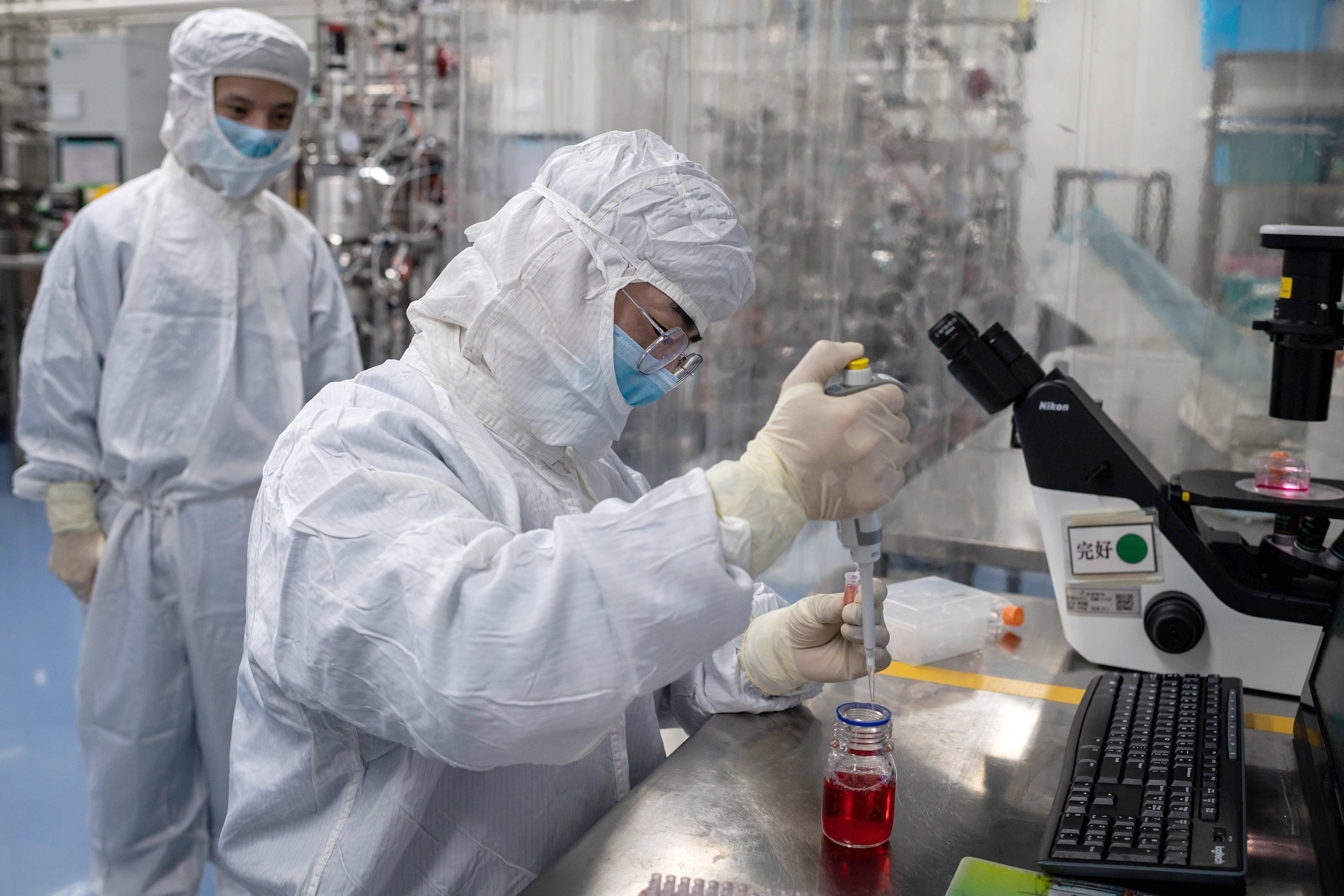 Ingeniero realiza pruebas en una vacuna experimental para el coronavirus covid-19 dentro de un laboratorio. Foto: AFP.