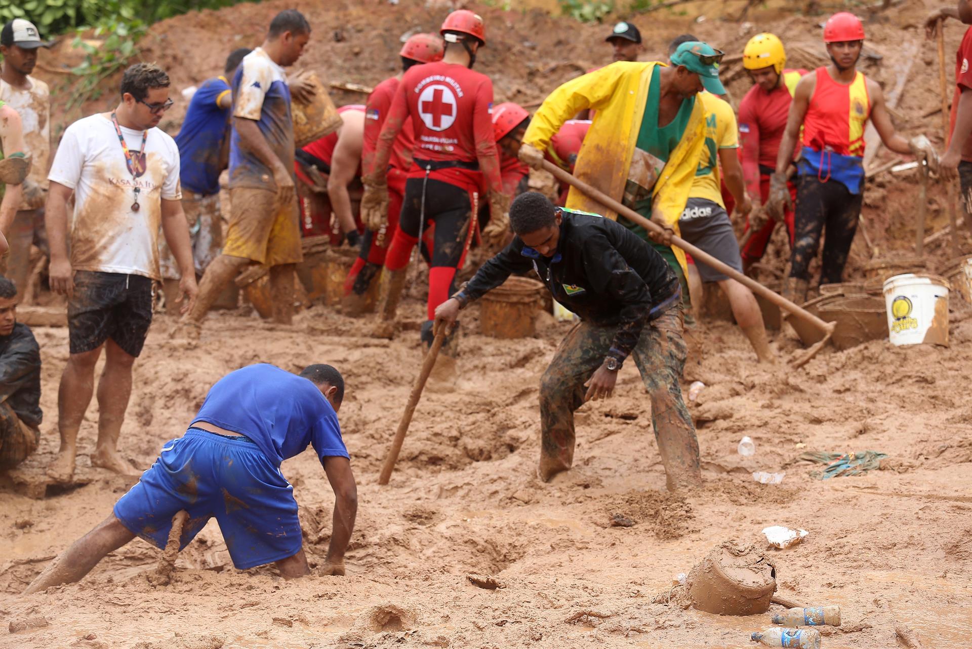 Residentes remueven escombros entre el lodo y el agua producto de las fuertes lluvias en el estado de Pernambuco. Foto: Efe