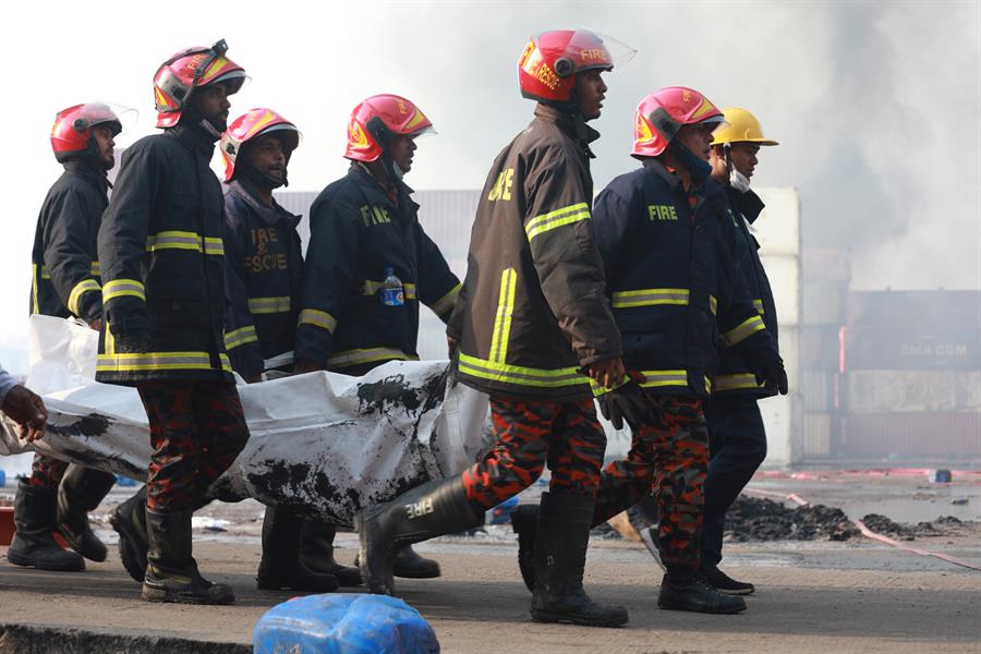 Bomberos llevan el cuerpo de uno de los fallecidos en incendio de depósito en Bangladesh. Foto: EFE/EPA/STR