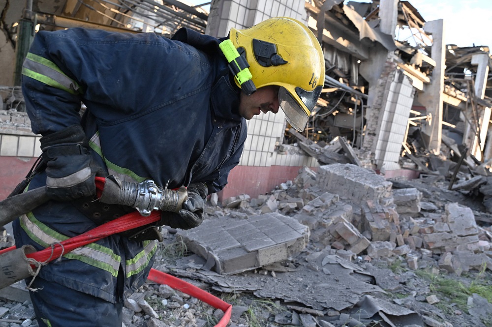 Los bomberos en un depósito de producción que fue objeto de ataques con misiles rusos en Kiev, Ucrania. Foto: AFP.
