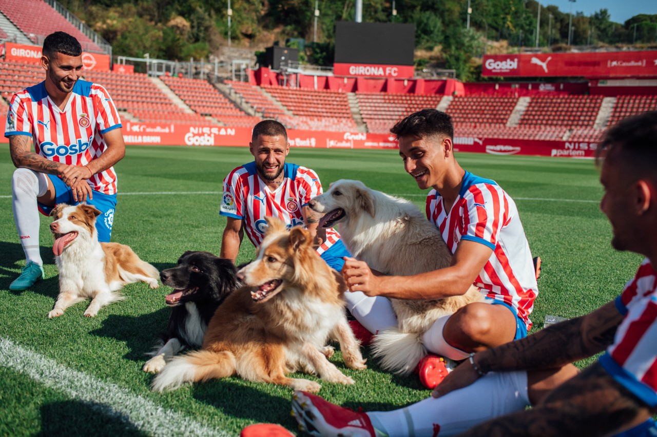 Jugadores del Girona posan con un perro como parte del acuerdo de patrocinio con Gosbi.
