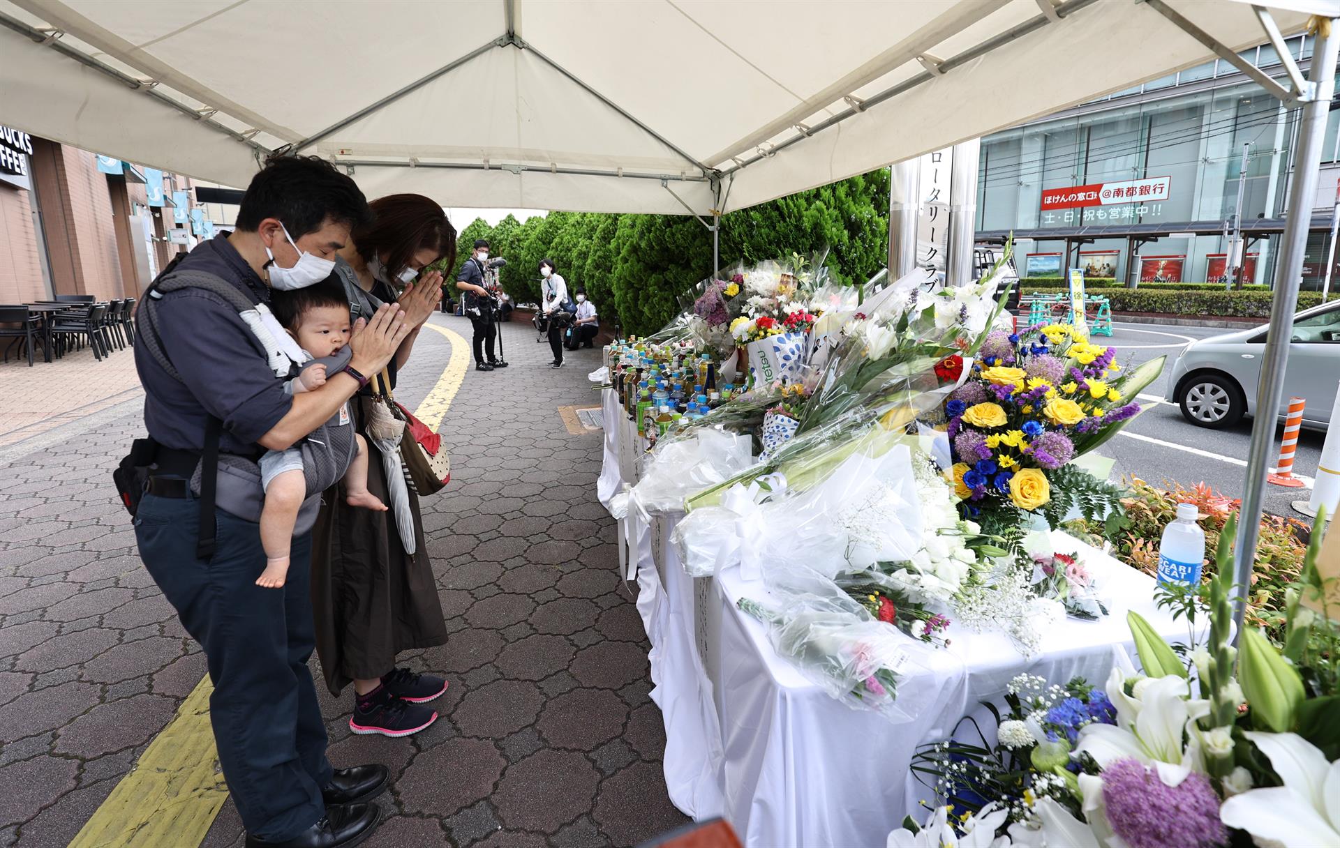Personas frente al altar de Shinzo Abe en el lugar del homicidio. Foto: EFE
