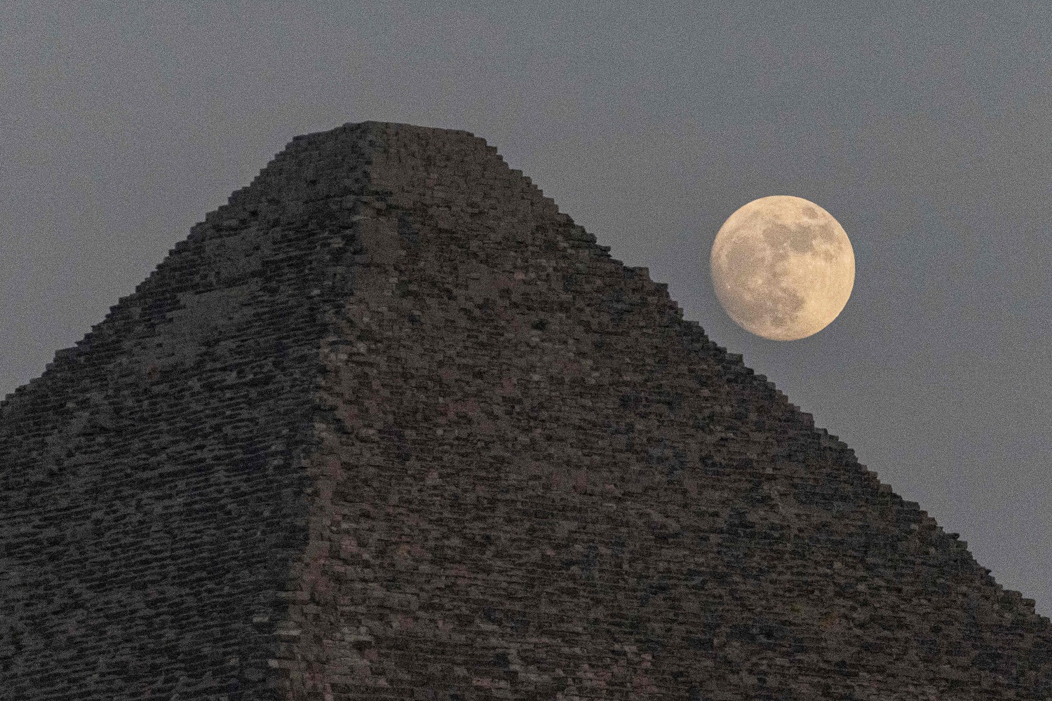 Luna llena detrás de una pirámide en Egipto. Foto: AFP