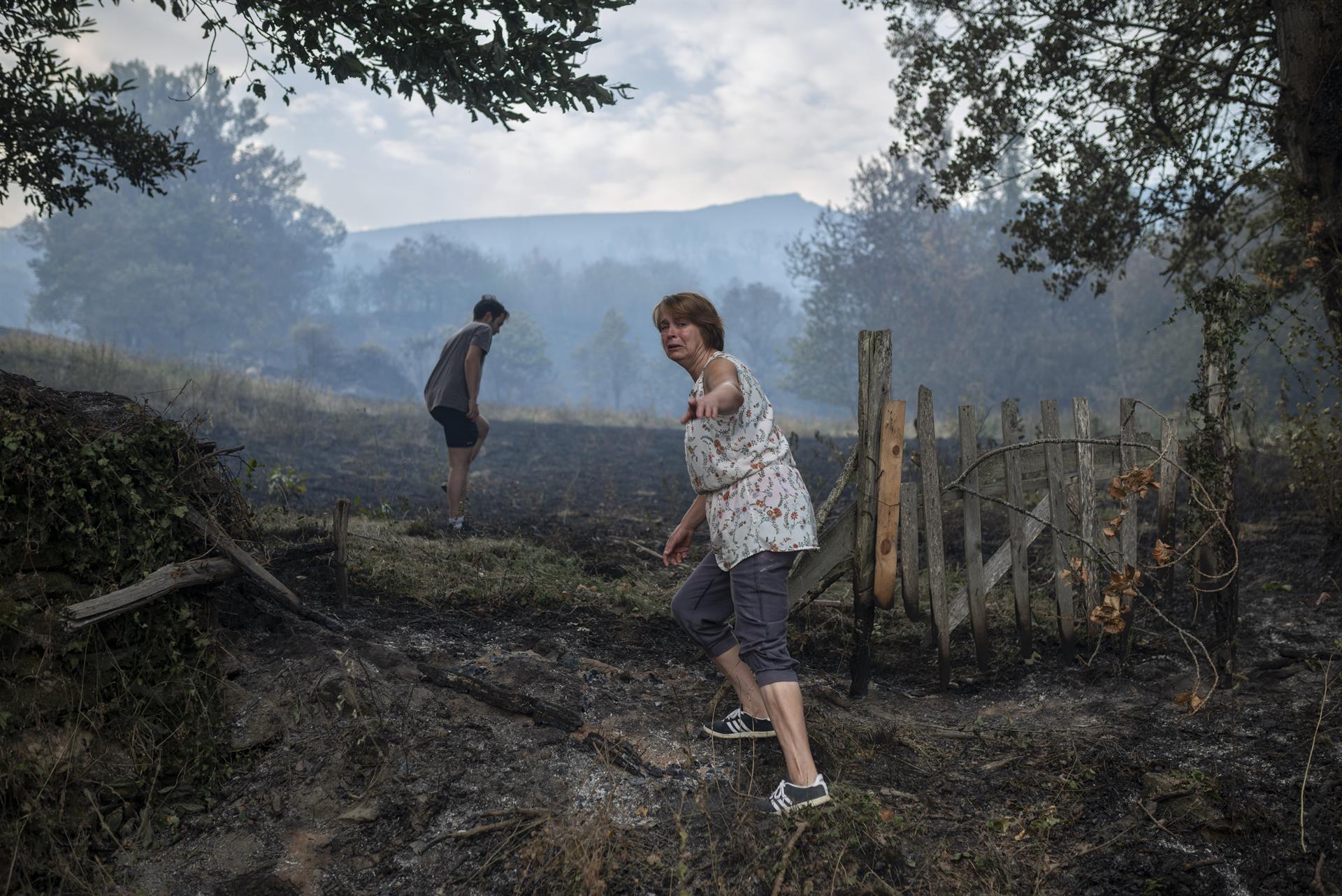 Incendios en Galicia. Una vecina de la localidad de Alixo llora al observar los daños causados por las llamas. Foto: EFE