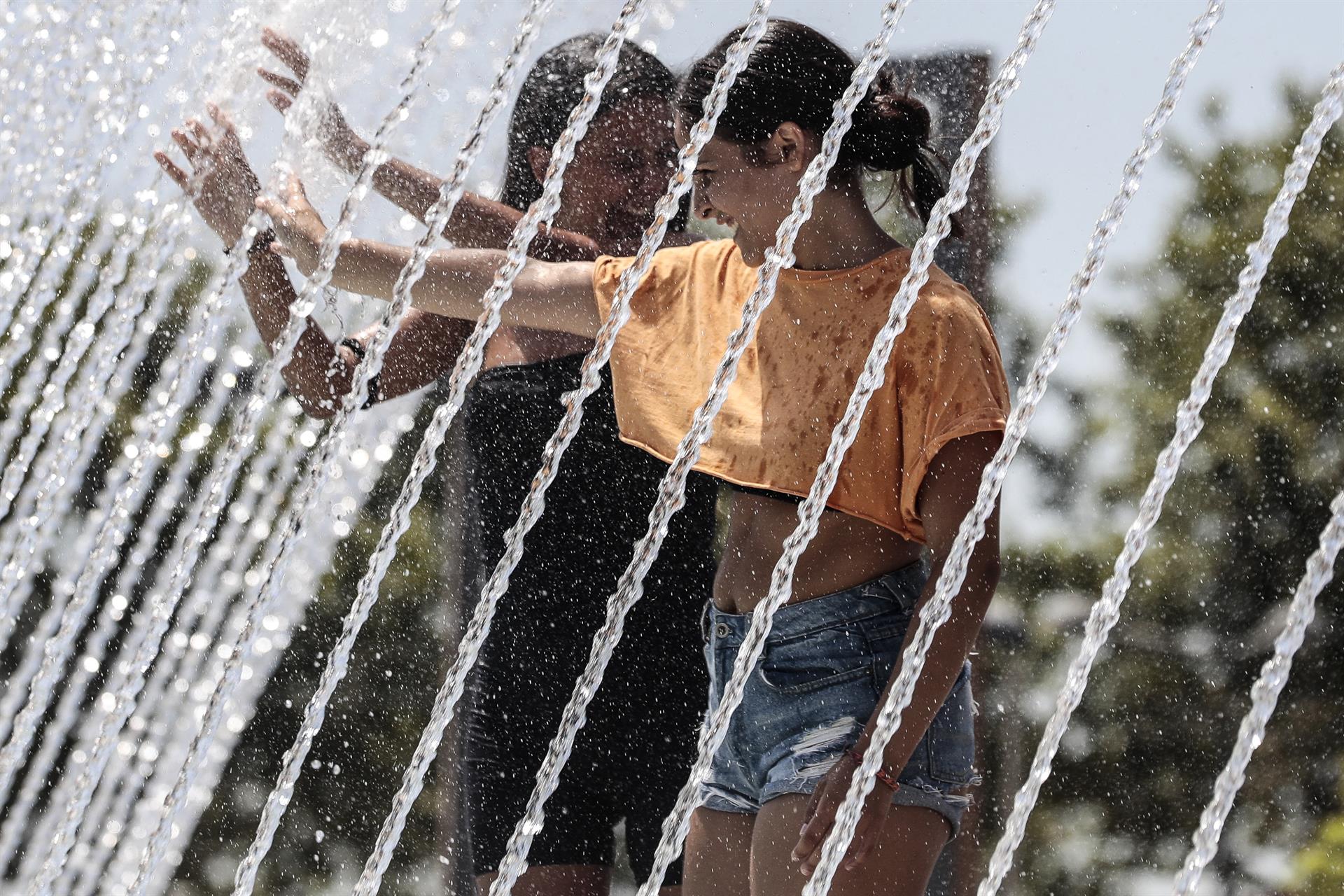 Ola de calor en Europa. Unas jóvenes se refrescan en una fuente este lunes en la ciudad de Valencia. Foto: EFE