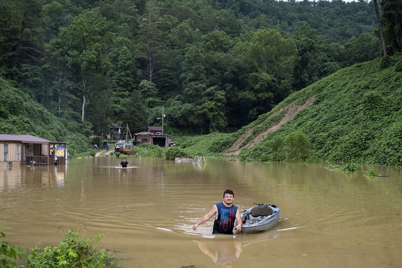 Hombre caminando tras inundaciones en Kentucky. Foto: AFP
