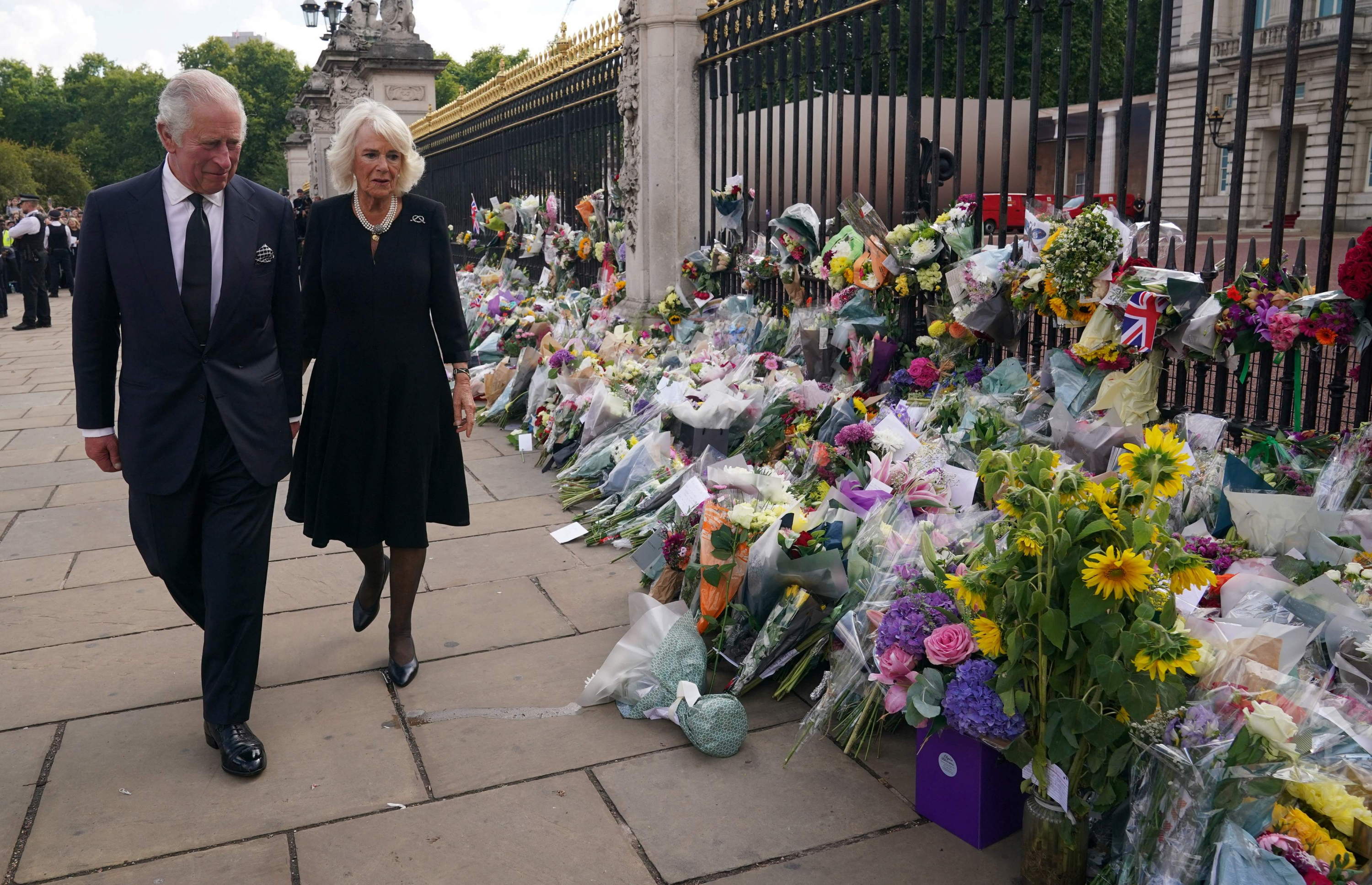 El rey Carlos III junto a la reina consorte, Camila, saludan a las personas que acompañan tras la muerte de la reina Isabel en Buckingham. Foto: AFP