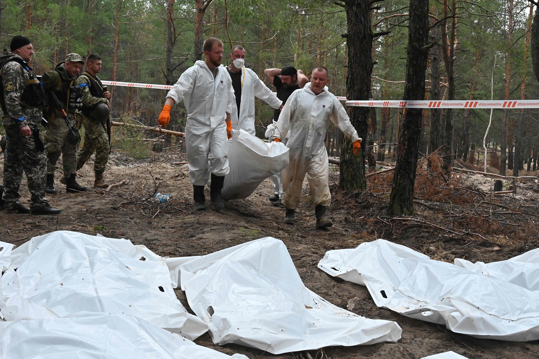 Cargan bolsas con los cuerpos encontrados en Izyum. Foto: AFP.