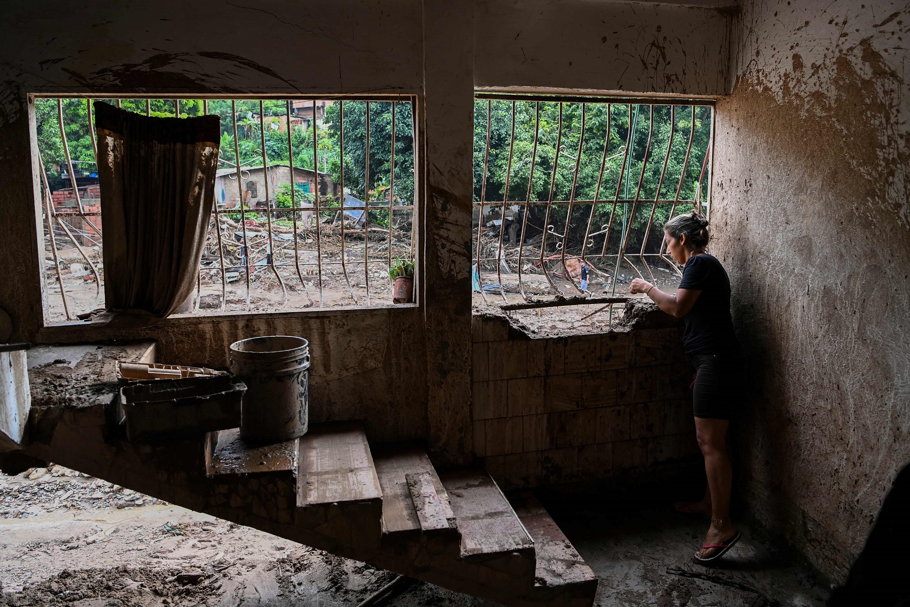 Mujer observa los desmanes provocados por el deslave en Las Tejería. Foto: AFP.