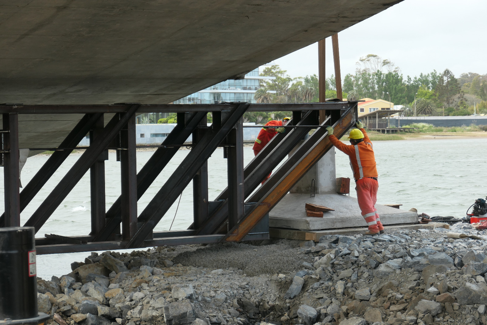 Personas trabajan en la colocación de una viga en el puente de La Barra, en Maldonado. Foto: Ricardo Figueredo.